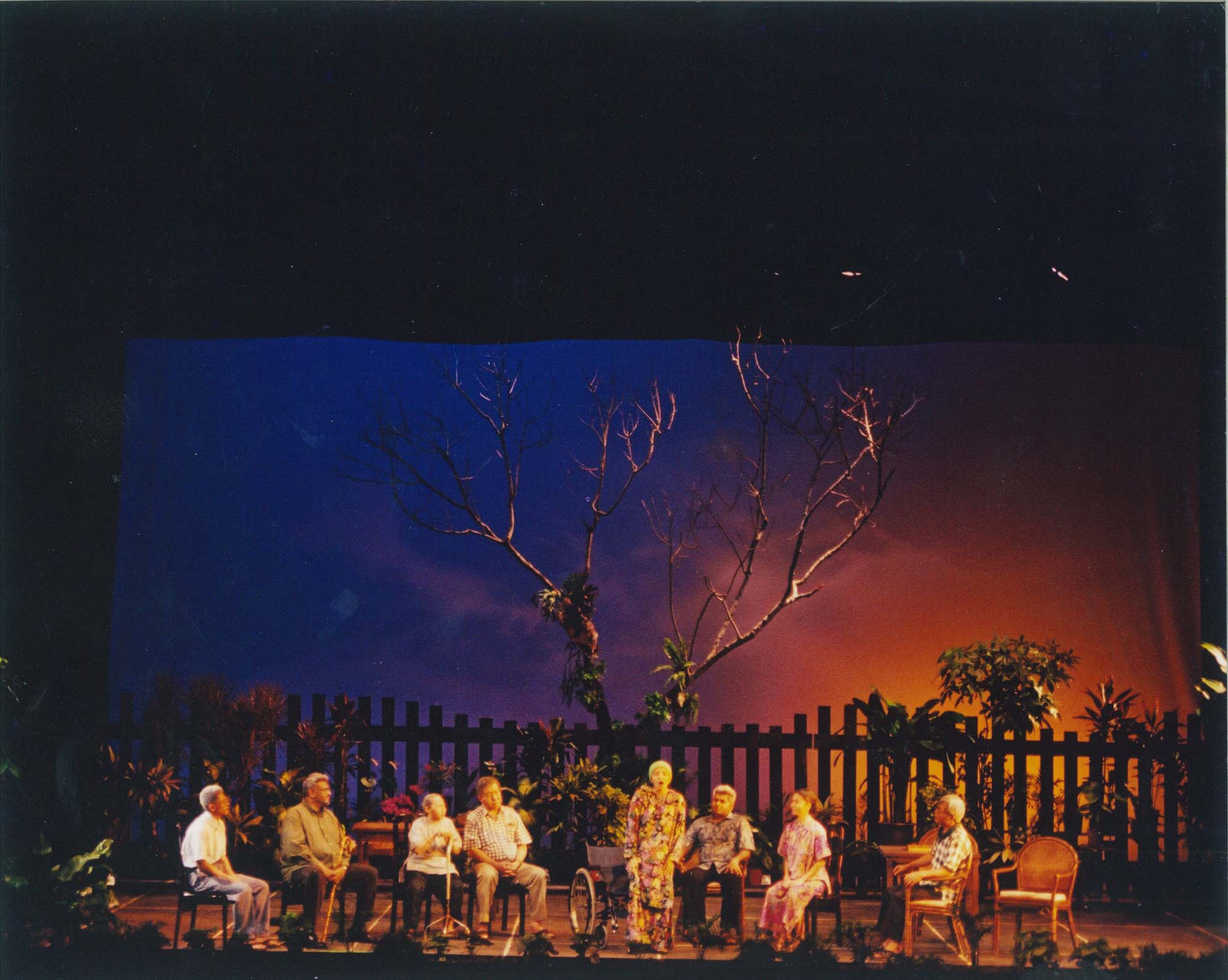 Photograph for Sunset Rise features actors on stage set against a backdrop of a gradient sunset
