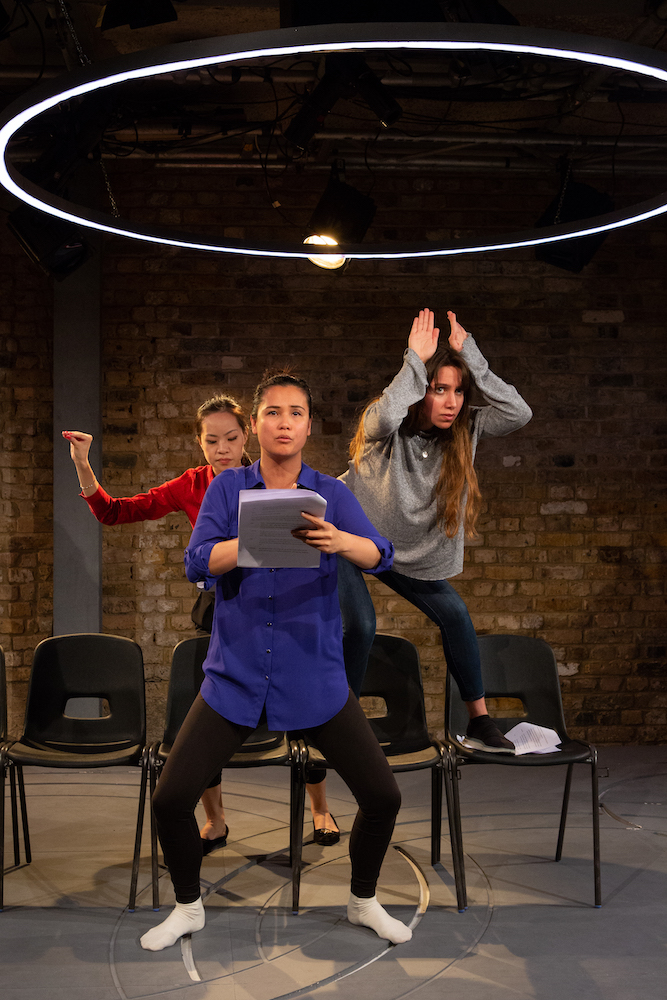 Three female-presenting persons, squatting slightly in various positions. Three female-presenting persons, squatting slightly in various positions.