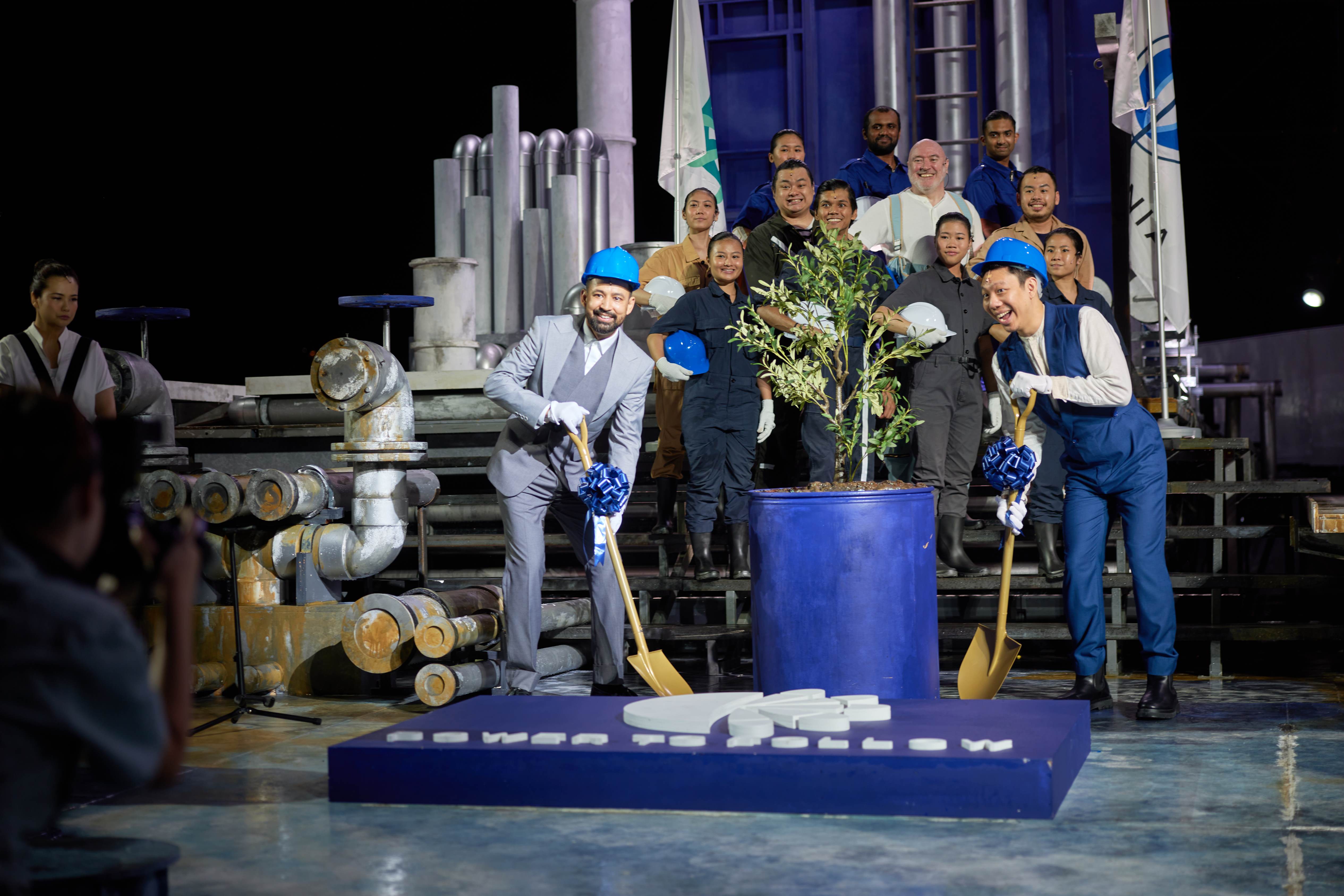 Construction workers posing for a photo with their planted plant.
