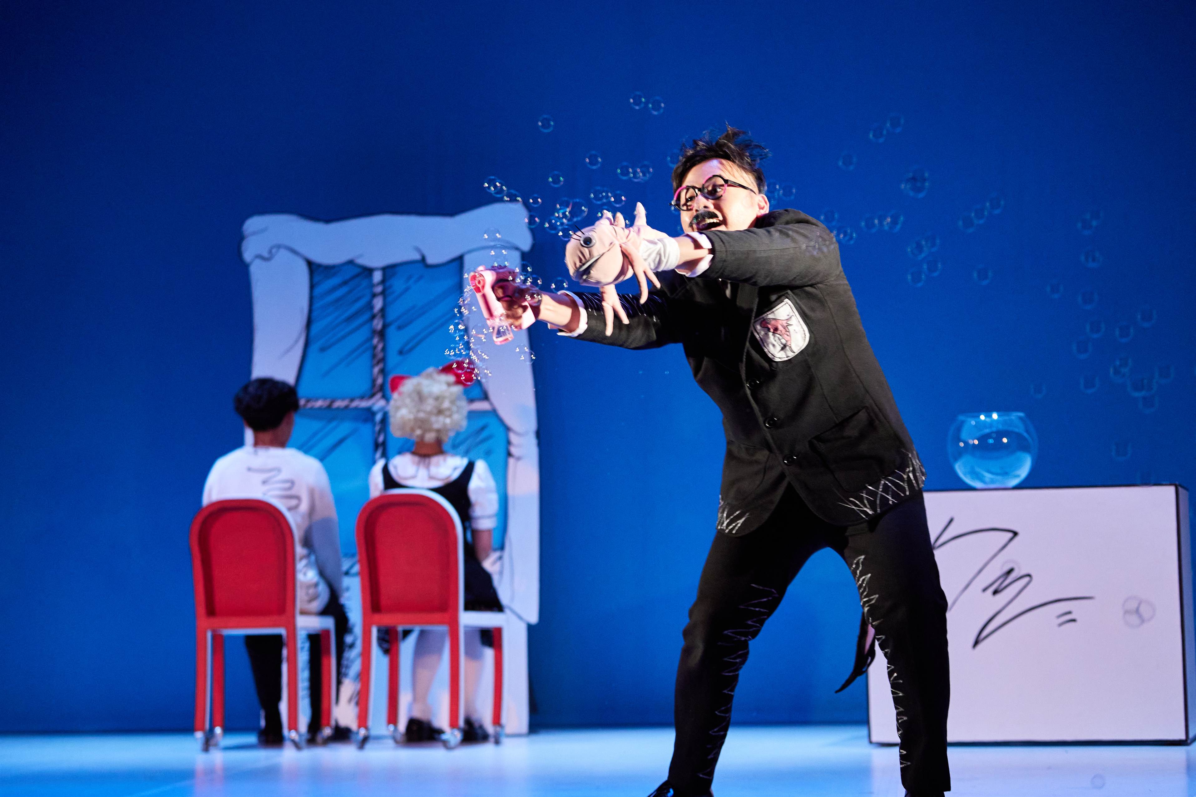 Male character shooting out bubbles to audience on downstage