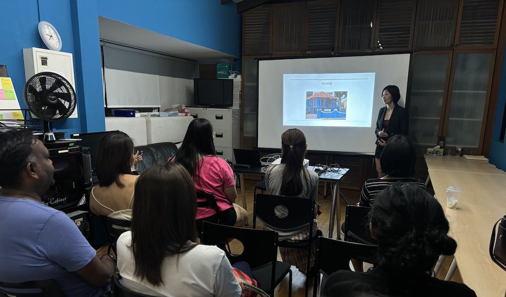 A large audience of people listening to a presentation.