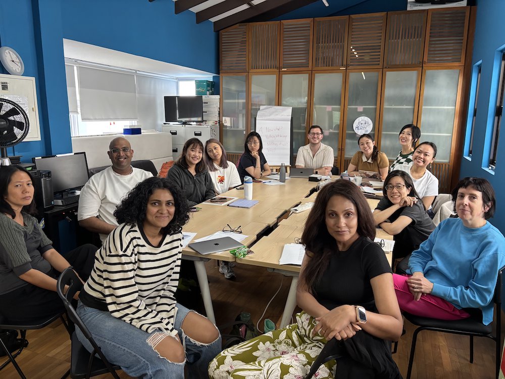 A group of people seated around a table, smiling.