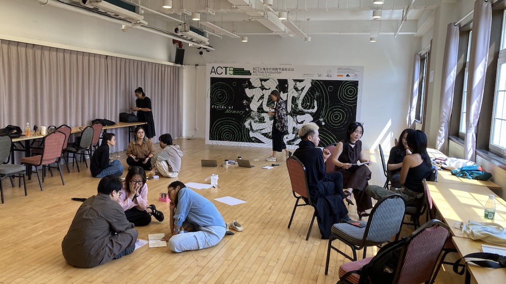 Three groups of people seated together in circles around a room, speaking to one another.