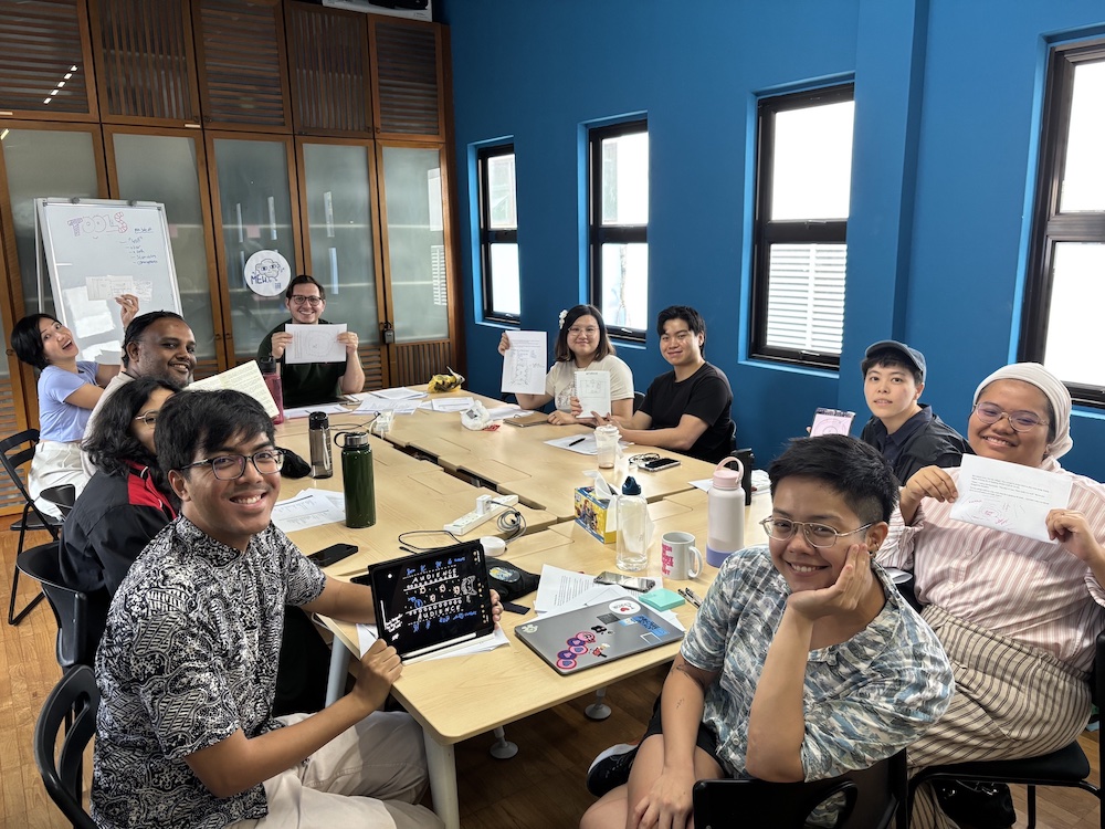 A group of people seated around a table, smiling.