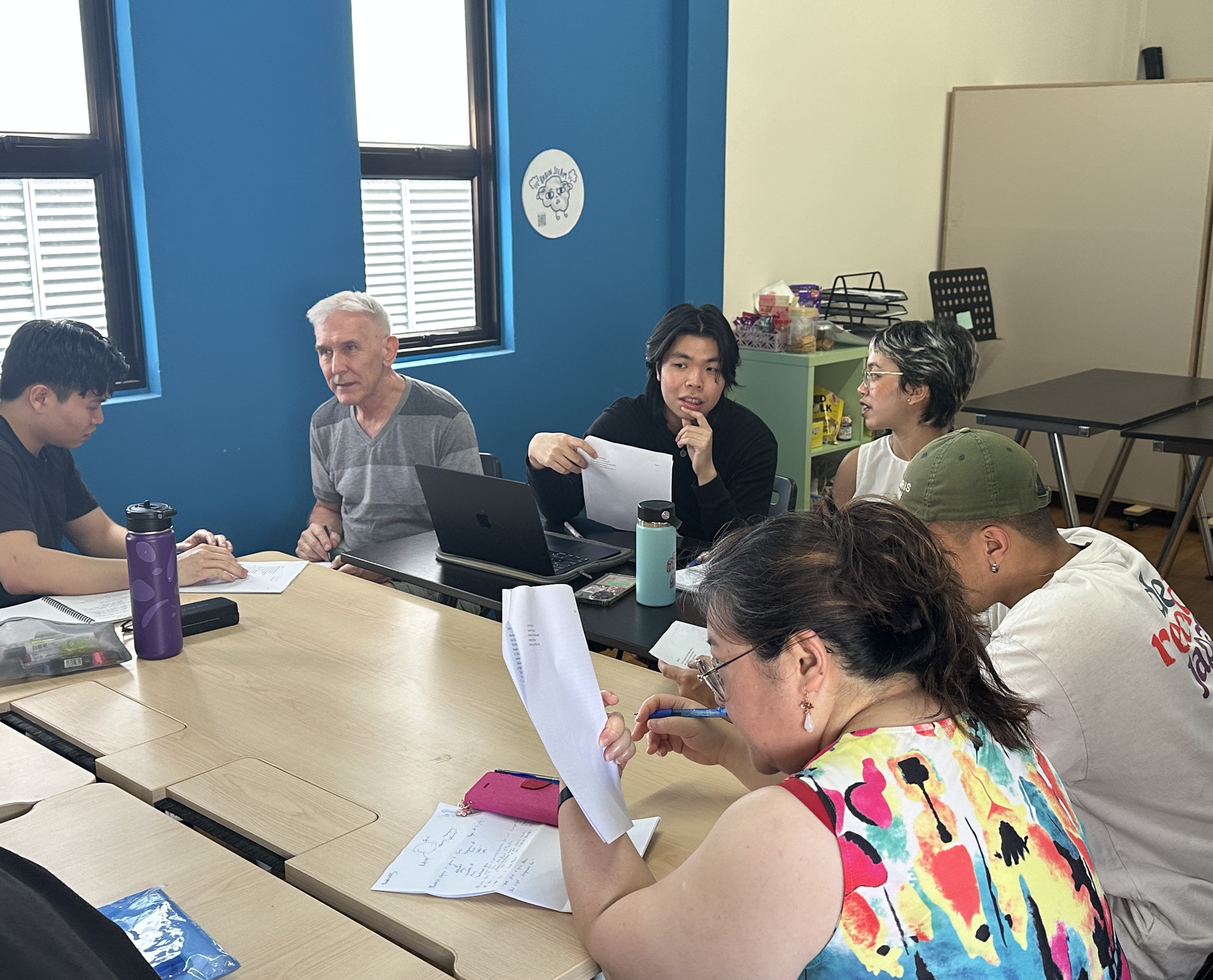 A photograph of participants seated around the tables and discussing with one another.